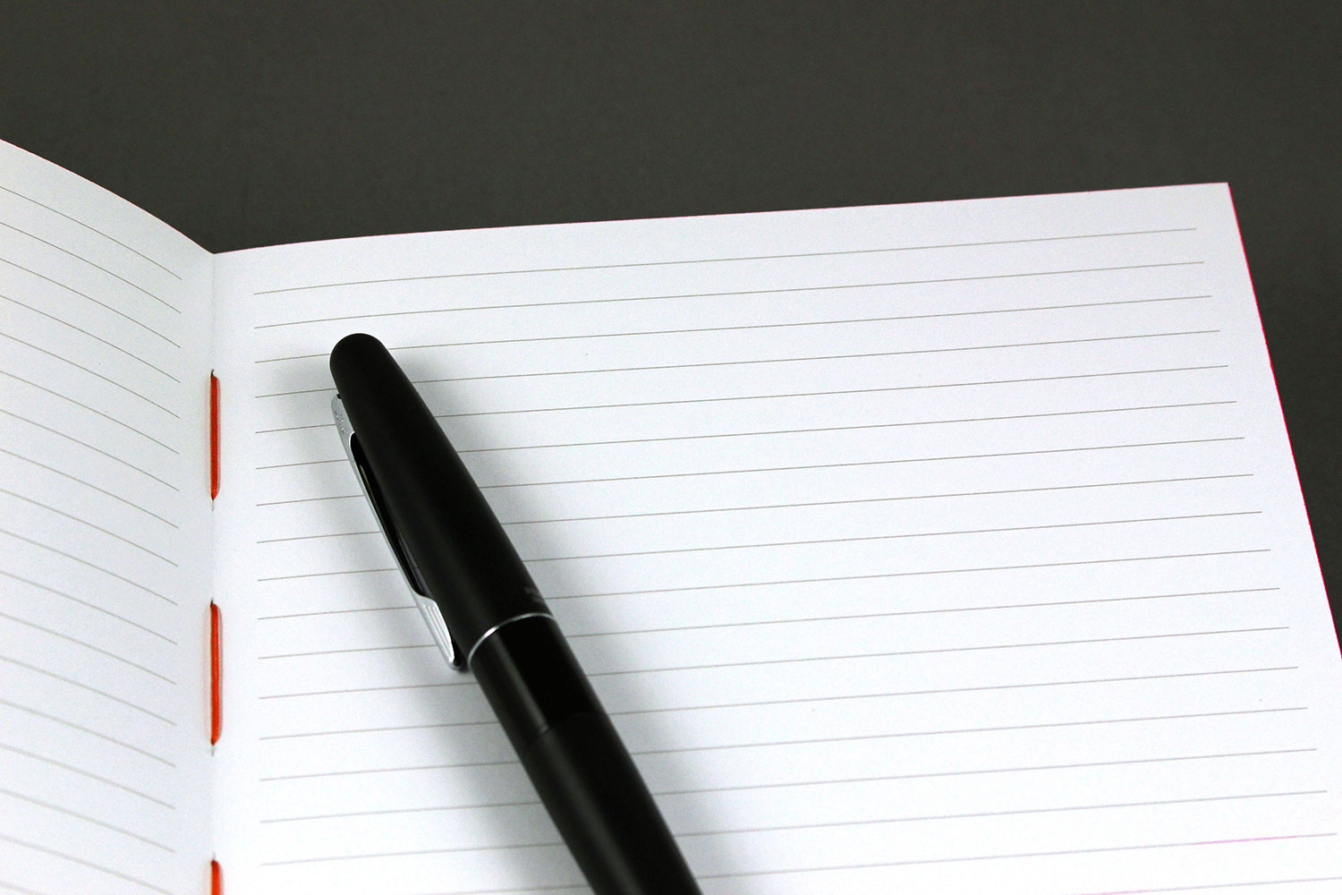 Notebook with black paper and white pen opened with page and white
